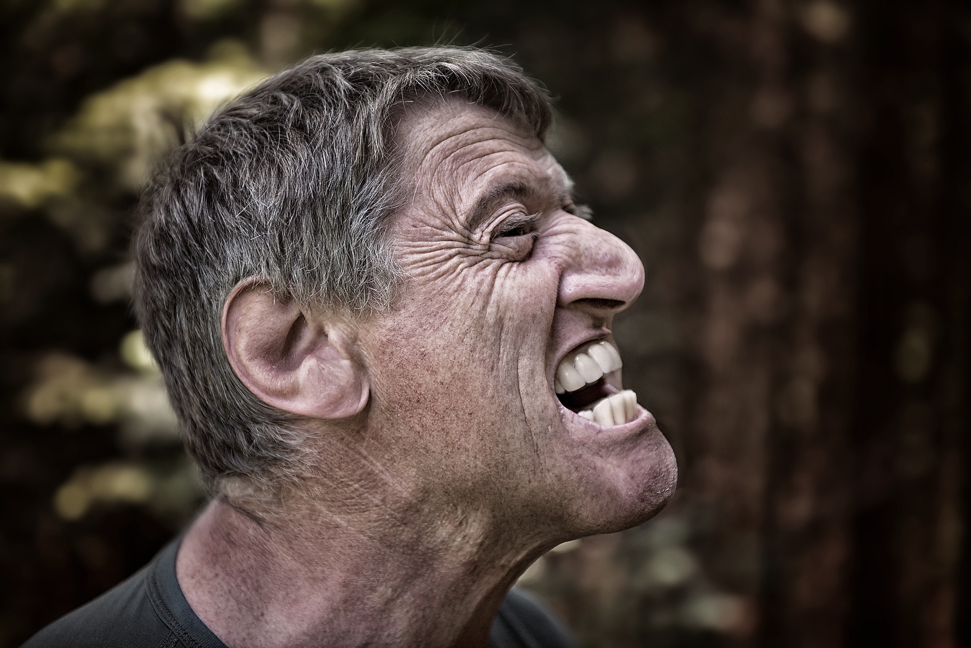 A man experiencing rage in the workplace with teeth clenched and bulging veins